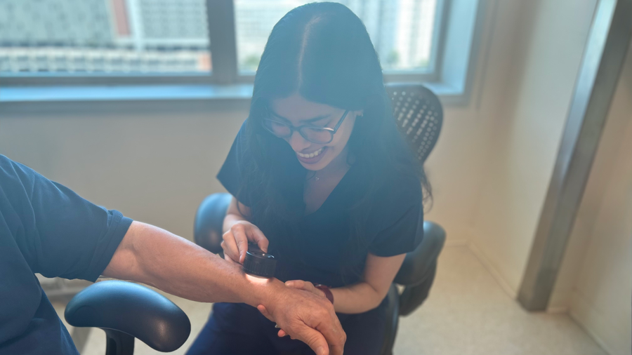 Medical professional using dermatoscope during skin exam